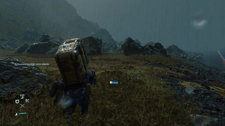 Сэм пересекает дождливую горную местность в Death Stranding