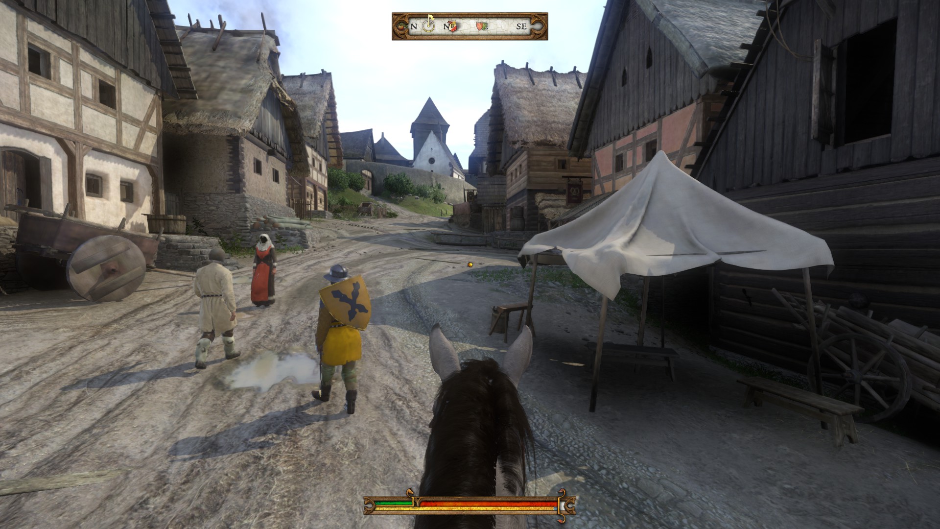 Всадник въезжает в средневековую деревню в Kingdom Come: Deliverance
